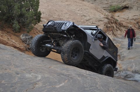 1991 Ford Bronco - A gray Jeep Wrangler JK navigates a rocky trail in a desert landscape.