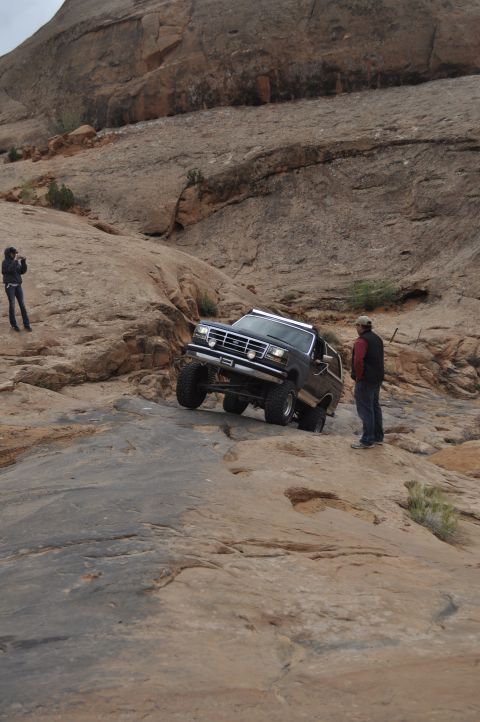 1991 Ford Bronco - Ford Bronco navigating a challenging off-road trail in a desert landscape.