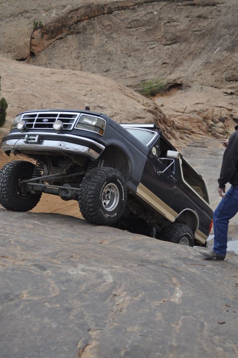 1991 Ford Bronco - A black 1991 Ford Bronco navigates a steep, rocky incline during an off-road excursion.
