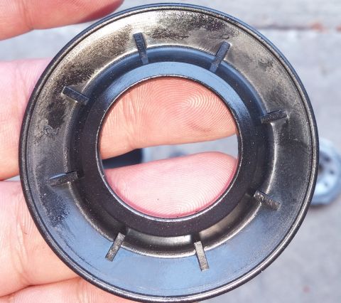 2000 Ford Crown Victoria - Black plastic oil filter housing with internal tabs is held by fingers.
