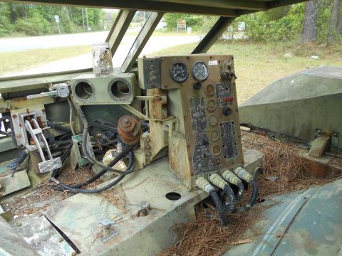 1992 Ford Bronco - The interior of a military vehicle reveals a complex dashboard filled with gauges, switches, and wiring, suggesting a specialized function.