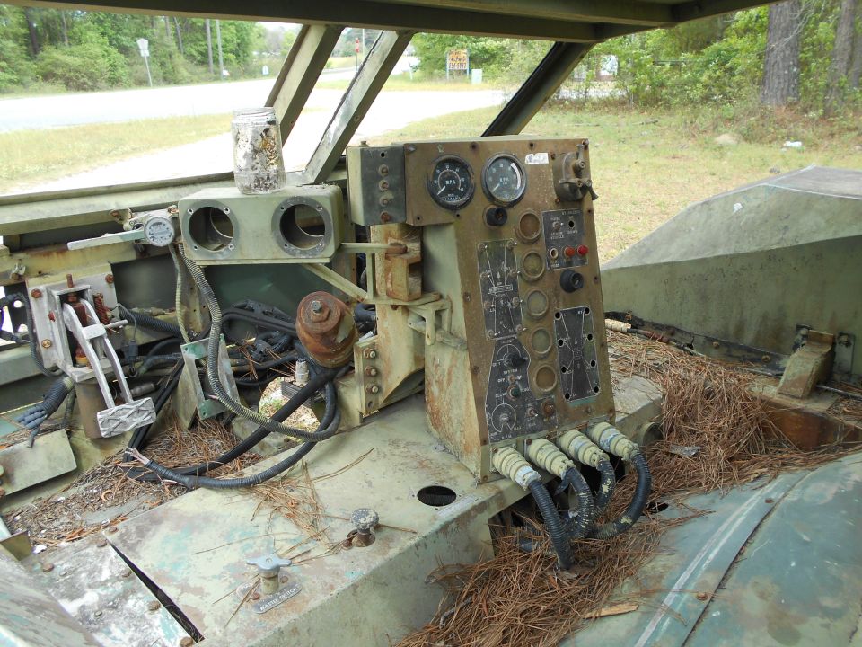 Interior of a military vehicle showing a complex dashboard with gauges and switches