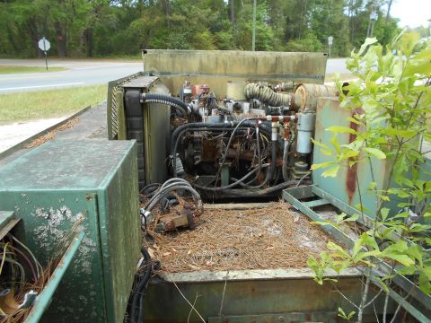 1992 Ford Bronco - This generator's engine compartment is exposed and appears weathered, with debris on the deck.