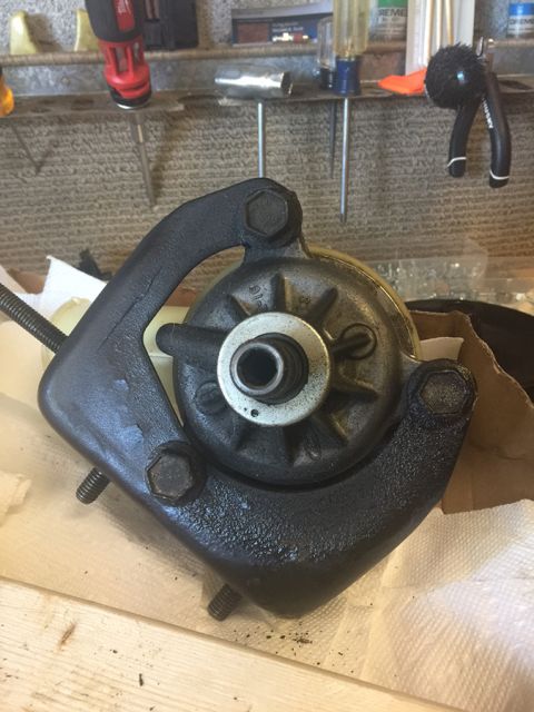1978 Ford Bronco - A close-up view of a black metal automotive component, likely a pump or motor housing, on a workbench.