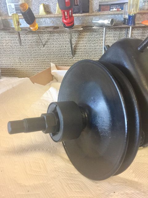 1978 Ford Bronco - Close-up of a black power steering pump pulley assembly, showing the threaded shaft and securing nut.