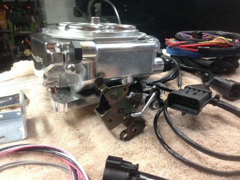 1979 Ford Bronco - A close-up view of a Holley Sniper EFI throttle body and its associated wiring harness, ready for installation.