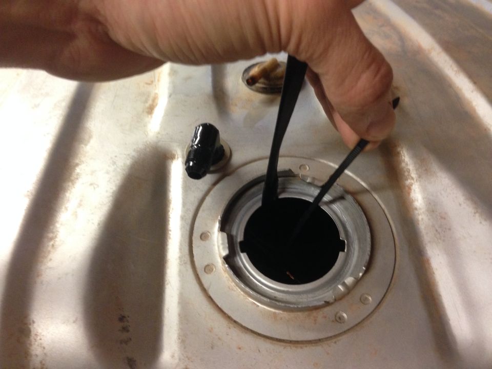 Fuel tank opening with a black gasket being inserted