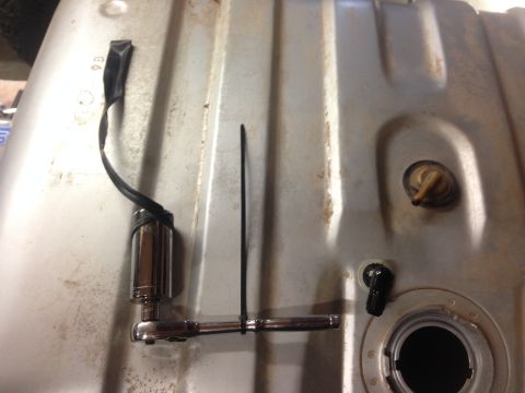 1979 Ford Bronco - Close-up view of a fuel tank undergoing a Holley Sniper installation, showing the fuel pump and a ratchet tool.