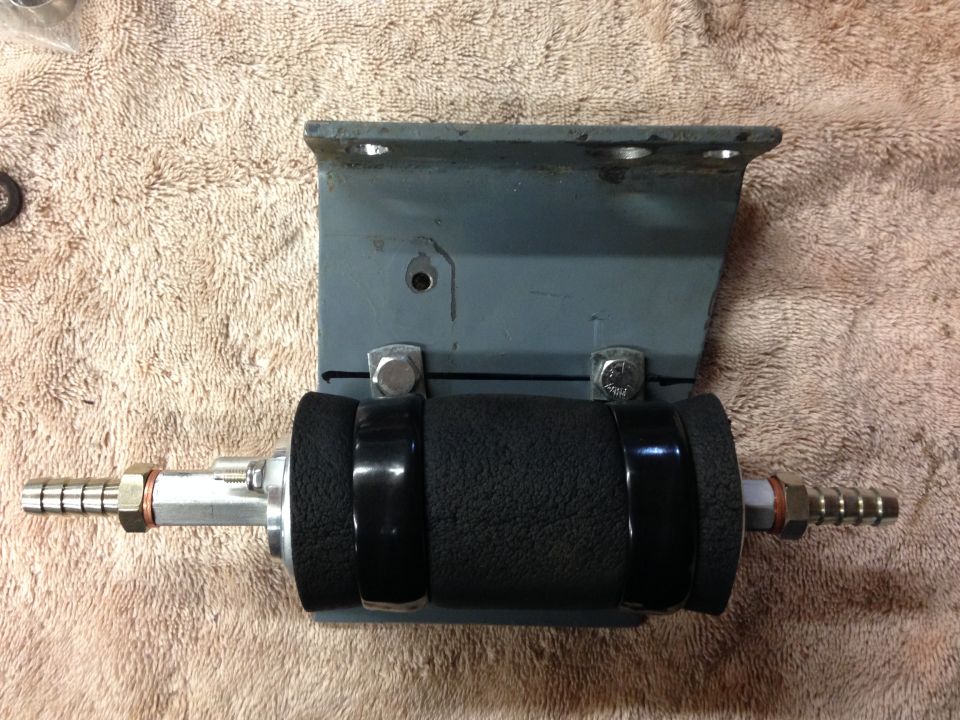 Fuel pump assembly with black foam grip mounted on a metal bracket