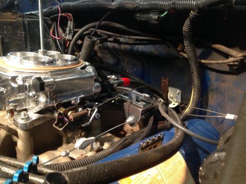 1979 Ford Bronco - Close-up of engine bay components, including a shiny carburetor and various wires and hoses.