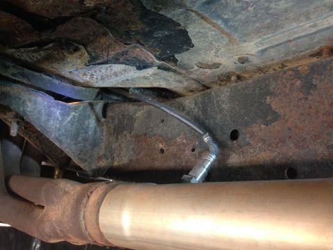 1979 Ford Bronco - Close-up view of an oxygen sensor mounted on the exhaust system, with visible frame and rust.