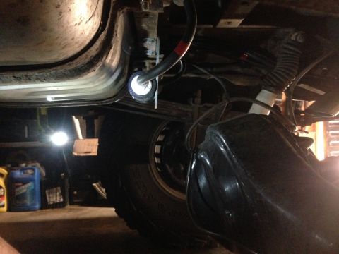 1979 Ford Bronco - Close-up of the underbody showing a fuel filter being installed, with suspension and exhaust components visible.