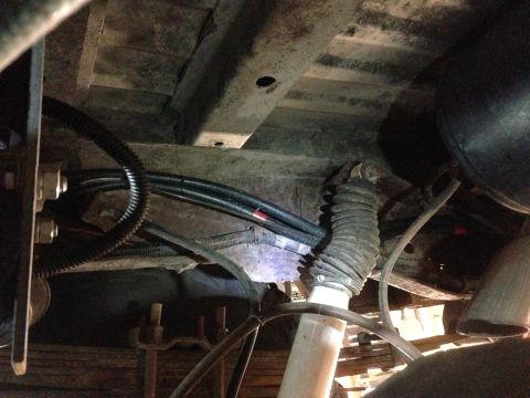 1979 Ford Bronco - Close-up of vehicle underbody, showing suspension and brake lines.