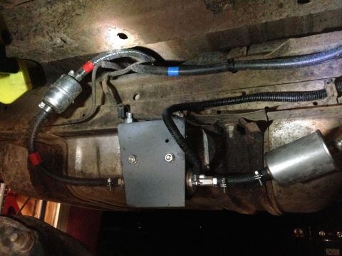 1979 Ford Bronco - Custom fuel system components are visible underneath a vehicle, including fuel filters and lines.