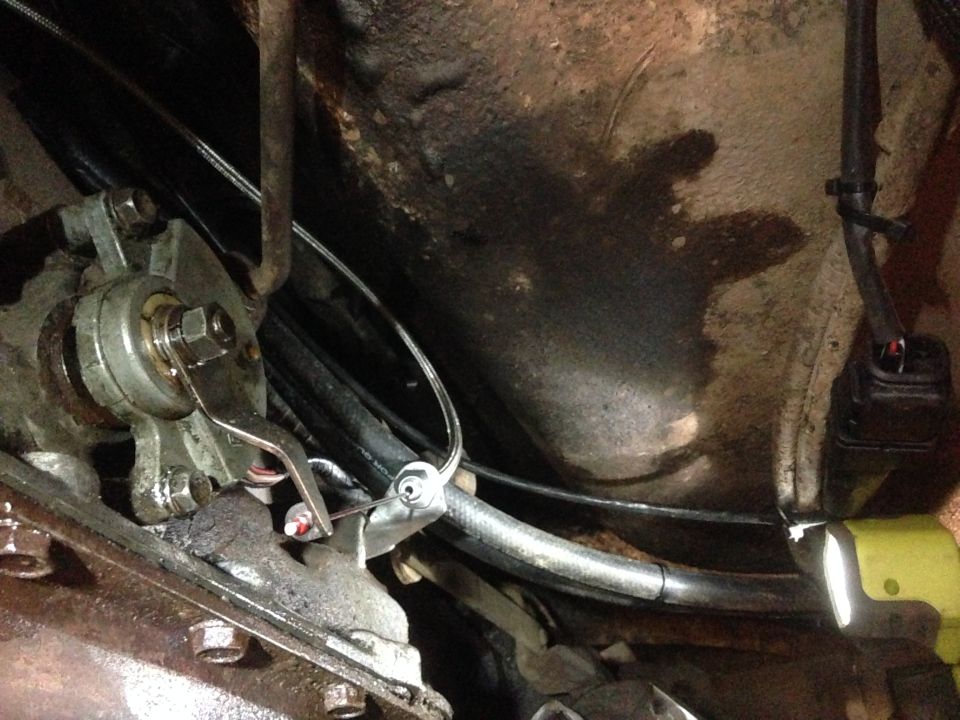 Undercarriage of a vehicle showing transmission linkage and cables