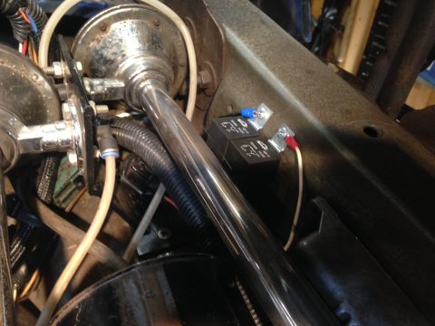 1979 Ford Bronco - Close-up view of a chrome horn and electrical relays installed in a vehicle's engine compartment.