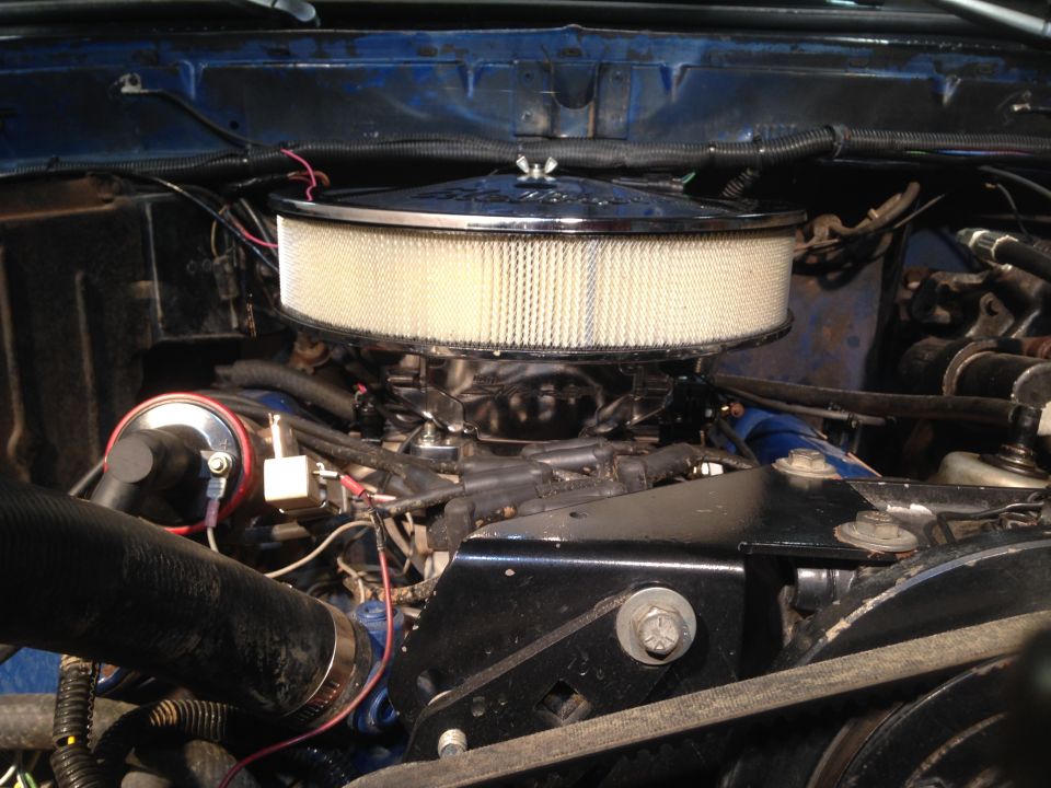 Engine bay showing carburetor and chrome air cleaner assembly. Blue painted inner fender visible