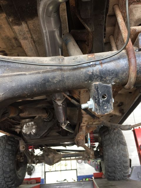 1979 Ford Bronco - A close-up view of the undercarriage reveals the suspension and exhaust system of a vehicle.