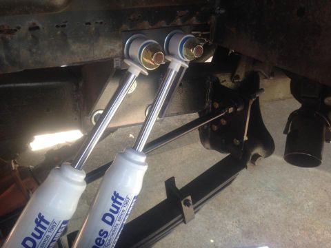 1972 Ford Bronco - Underside view of a vehicle's suspension system, showing new shock absorbers installed on leaf springs.