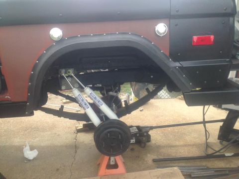 1972 Ford Bronco - The rear suspension of a 1972 Ford Bronco is visible, showing dual shock absorbers and leaf springs during a restoration process.