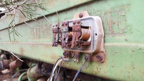 1973 Ford F-100 - An old, corroded electrical relay is mounted on the side of a weathered green piece of equipment.
