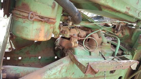 1973 Ford F-100 - Close-up view of a weathered green tractor engine, revealing mechanical components and signs of age.