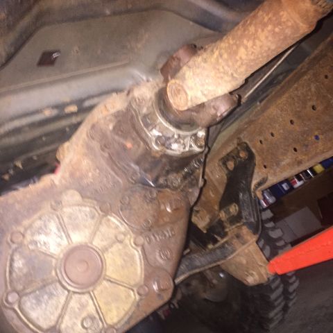 1982 Ford Bronco - Underside view of a rusty transfer case and driveshaft assembly, likely from an older truck or SUV.