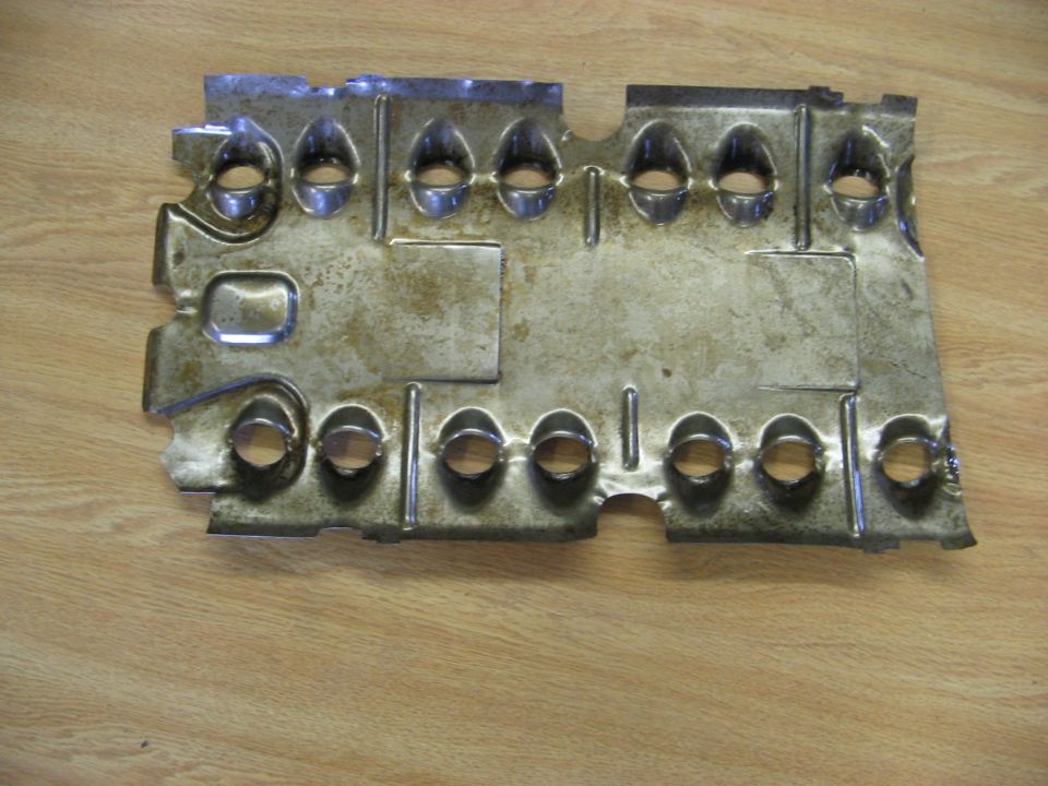 Metal heat shield with multiple stamped holes and some discoloration