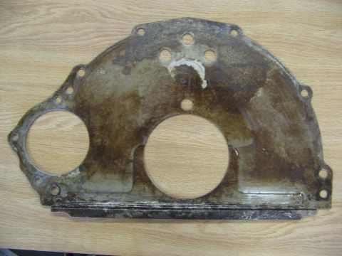 1968 Mercury Cougar - A used engine timing cover gasket is shown flat on a wooden surface.