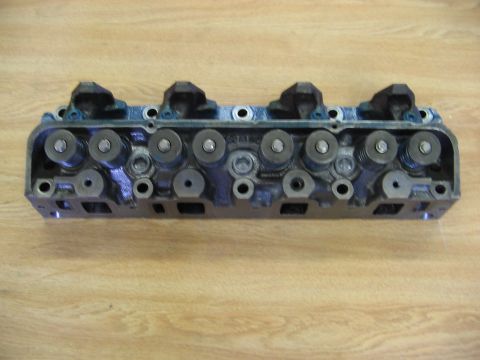 1968 Mercury Cougar - An engine cylinder head is shown against a wooden background.
