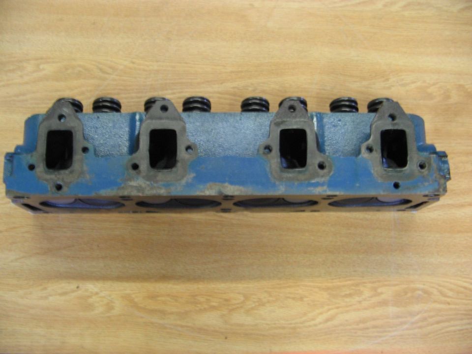 Blue engine cylinder head with four intake ports visible