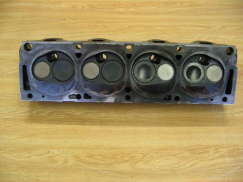 1968 Mercury Cougar - Engine cylinder head shown on a wooden surface. This is a mechanical part, not a complete vehicle.