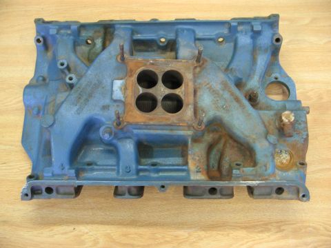 1968 Mercury Cougar - This blue intake manifold shows signs of wear and rust, with four distinct openings for a carburetor.