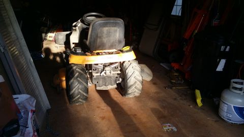 2007 Subaru Impreza - Riding lawn mower with large rear tires is parked in a dimly lit garage.