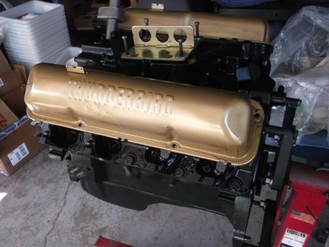 1964 Ford Galaxie - A black engine block with gold valve covers that read "Thunderbird" is shown in a workshop setting.