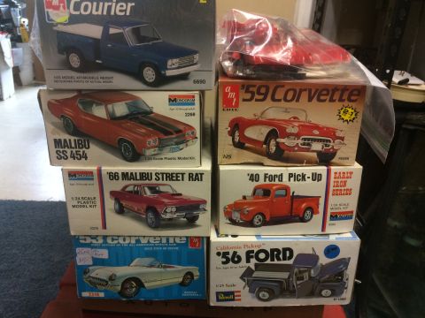 1989 Ford Bronco - A collection of unassembled plastic model car kits are stacked and displayed.