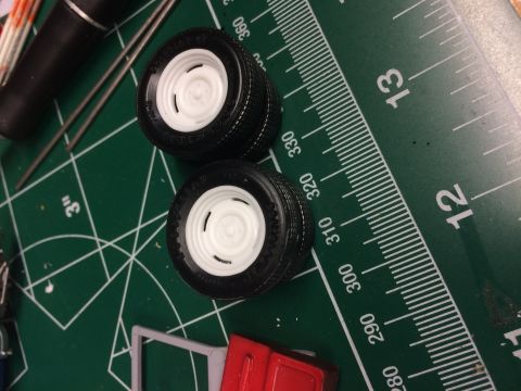 1989 Ford Bronco - Model car wheels and parts are laid out on a cutting mat next to a ruler, suggesting a hobbyist's project.