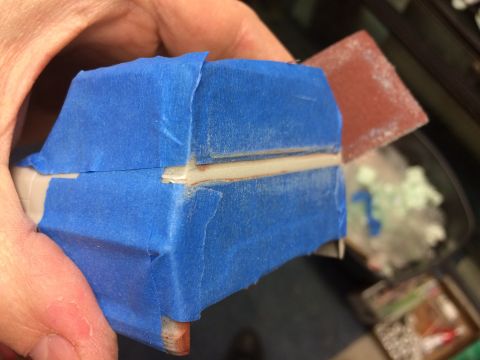 1989 Ford Bronco - A model car body piece is covered in blue tape, ready for detailing or painting.