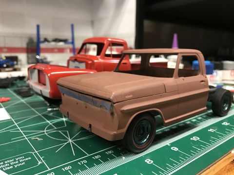 1989 Ford Bronco - Two unfinished model truck kits are on a green cutting mat with rulers, ready for assembly and painting.