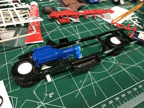 1989 Ford Bronco - Model car assembly in progress, showing the chassis, engine, and transmission components.