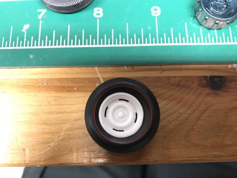 1989 Ford Bronco - A model car wheel with a redline tire is shown on a wooden surface, with a ruler and other model parts in the background.