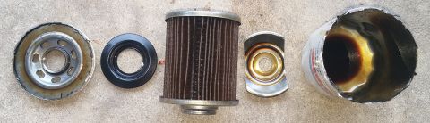 2000 Ford Crown Victoria - A disassembled oil filter lies on a concrete surface, showing its internal components.