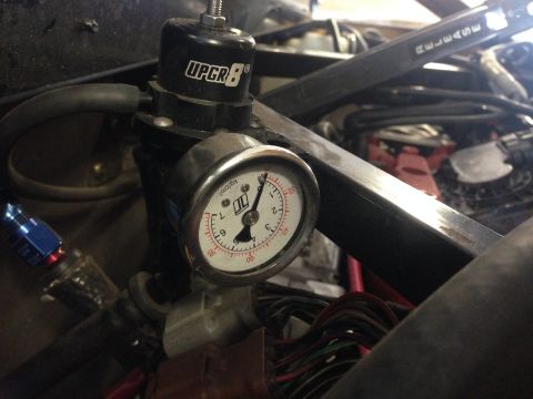 2015 Subaru Impreza - This image shows a close-up of a fuel pressure regulator with a gauge, surrounded by engine components and wiring.