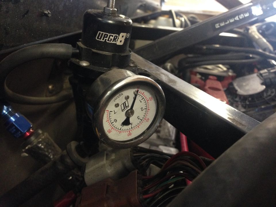 Close-up of an UPGR8 fuel pressure regulator and gauge, showing fuel lines and wiring