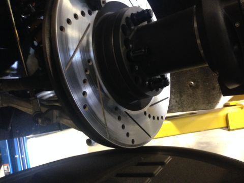 2015 Subaru Impreza - Close-up view of a drilled and slotted brake rotor, part of a vehicle's braking system.
