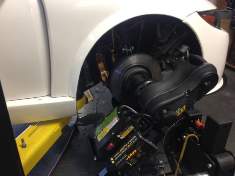 2015 Subaru Impreza - Car's front wheel and brake assembly with a wheel alignment machine attached.