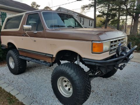 1988 Ford Bronco - This lifted Ford Bronco features a two-tone paint scheme and aftermarket bumper.