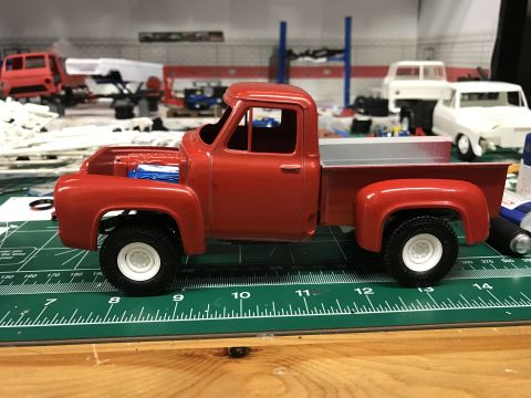 1989 Ford Bronco - A partially assembled red model truck sits on a green cutting mat with other model kits in the background.