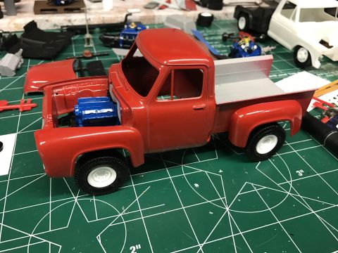1989 Ford Bronco - Model truck kit assembly in progress on a cutting mat, with other parts and models visible.