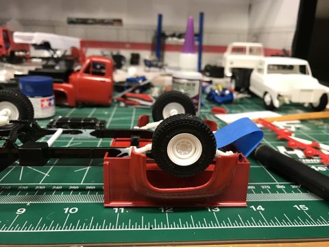 1989 Ford Bronco - Model truck parts are laid out on a green cutting mat, with a red chassis in the foreground.